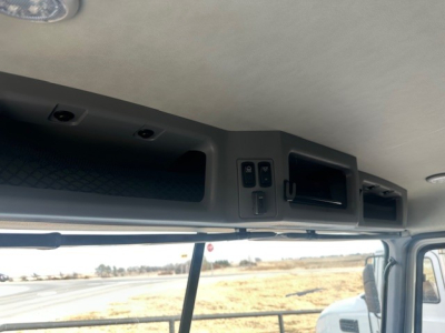 Cab interior overhead controls area showing storage compartment and switches in Mack GR64F dump truck cab.