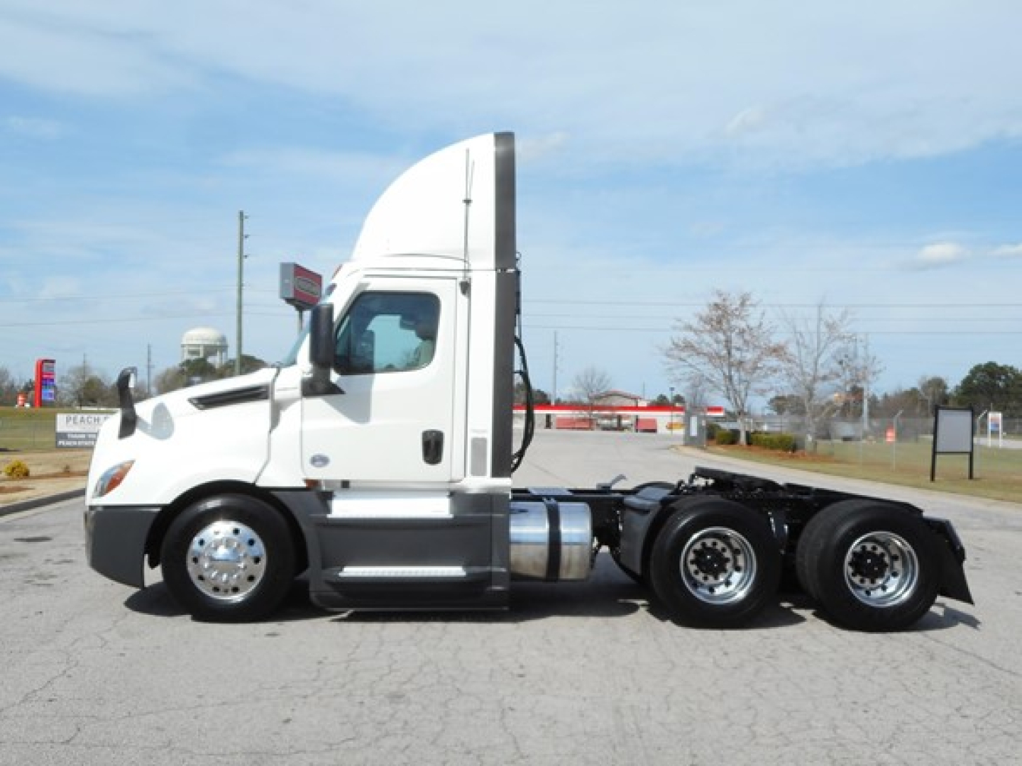 Tractor unit side view showing Freightliner Cascadia 126 2021 with multiple axles and sleeper cab