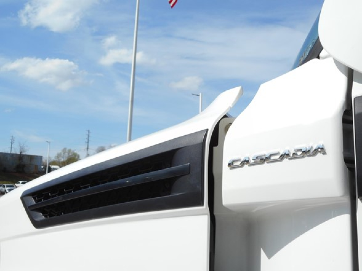 Truck cab side showing CASCADIA badge on a white Freightliner Cascadia 126 day cab.