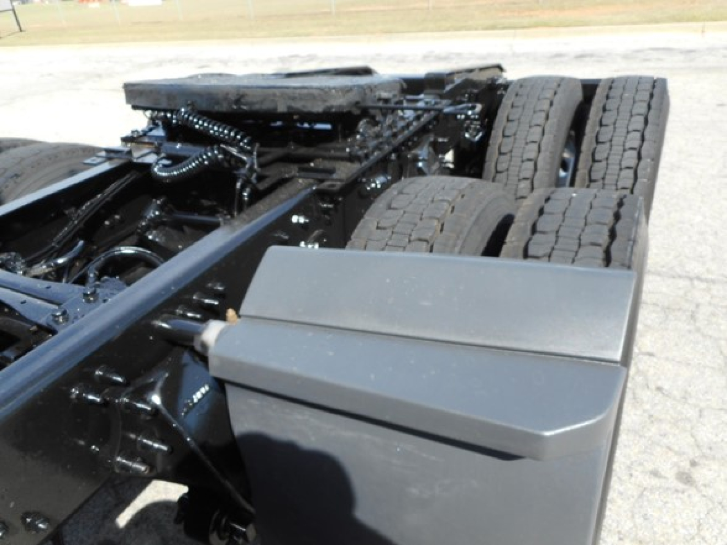 Freightliner Cascadia chassis with dual rear axles, fuel tank and frame visible; no legible text on components in view.