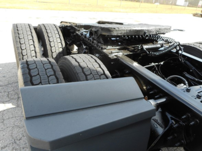 Freightliner Cascadia chassis showing dual rear axles and frame with suspension components.