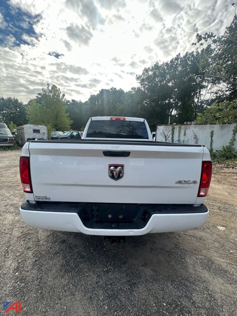 Ram 1500 pickup tailgate with 4x4 badge visible in rear view, white exterior, back of truck parked on gravel lot.