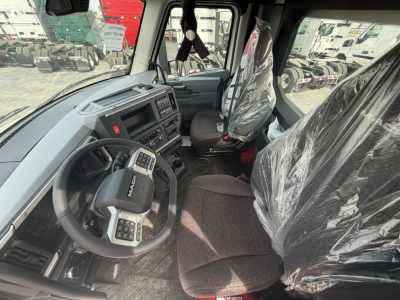 Interior of a 2027 Mack AN64T daycab showing steering wheel, dashboard, and driver seat wrapped in plastic.