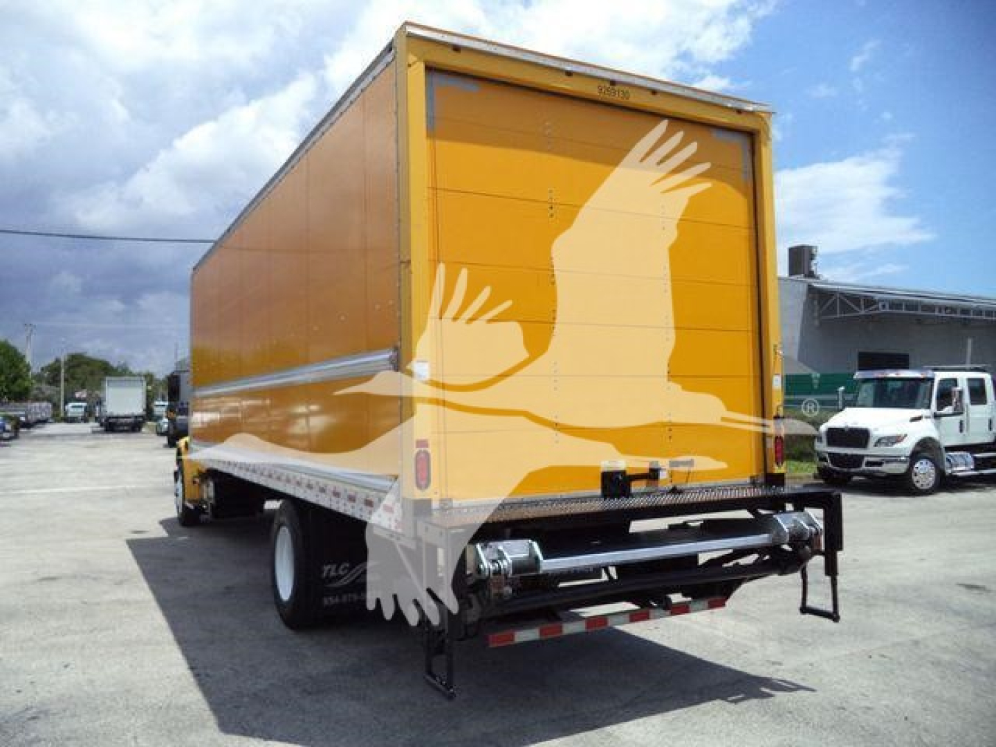 Truck rear view of a 2019 Freightliner M2 106 box truck with yellow cargo body and rear underride guard.