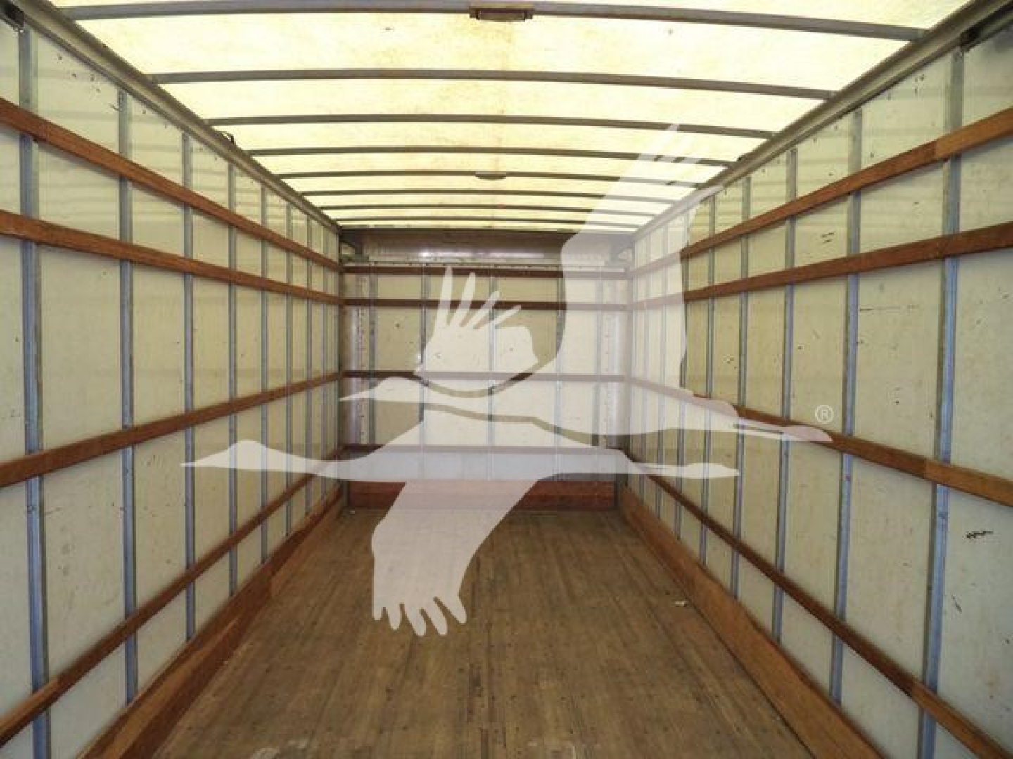 Truck interior cargo area of a 2019 Freightliner M2 106 showing empty box with wooden floor and metal side rails.