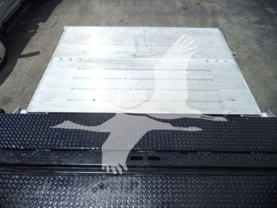 Freightliner M2 106 truck bed area showing aluminum cargo plate and black diamond plate step at rear