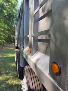 Truck side of a 2004 Peterbilt 378 dump truck showing grey side panels, wheels, and clearance/marker lights.