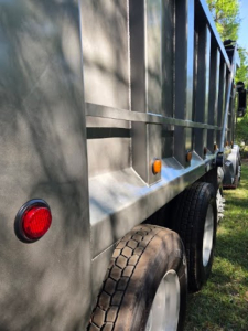 Truck side showing dump bed and dual rear wheels