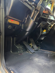 Peterbilt 378 dump truck interior pedal area and dashboard view showing floor pedals and control panels.