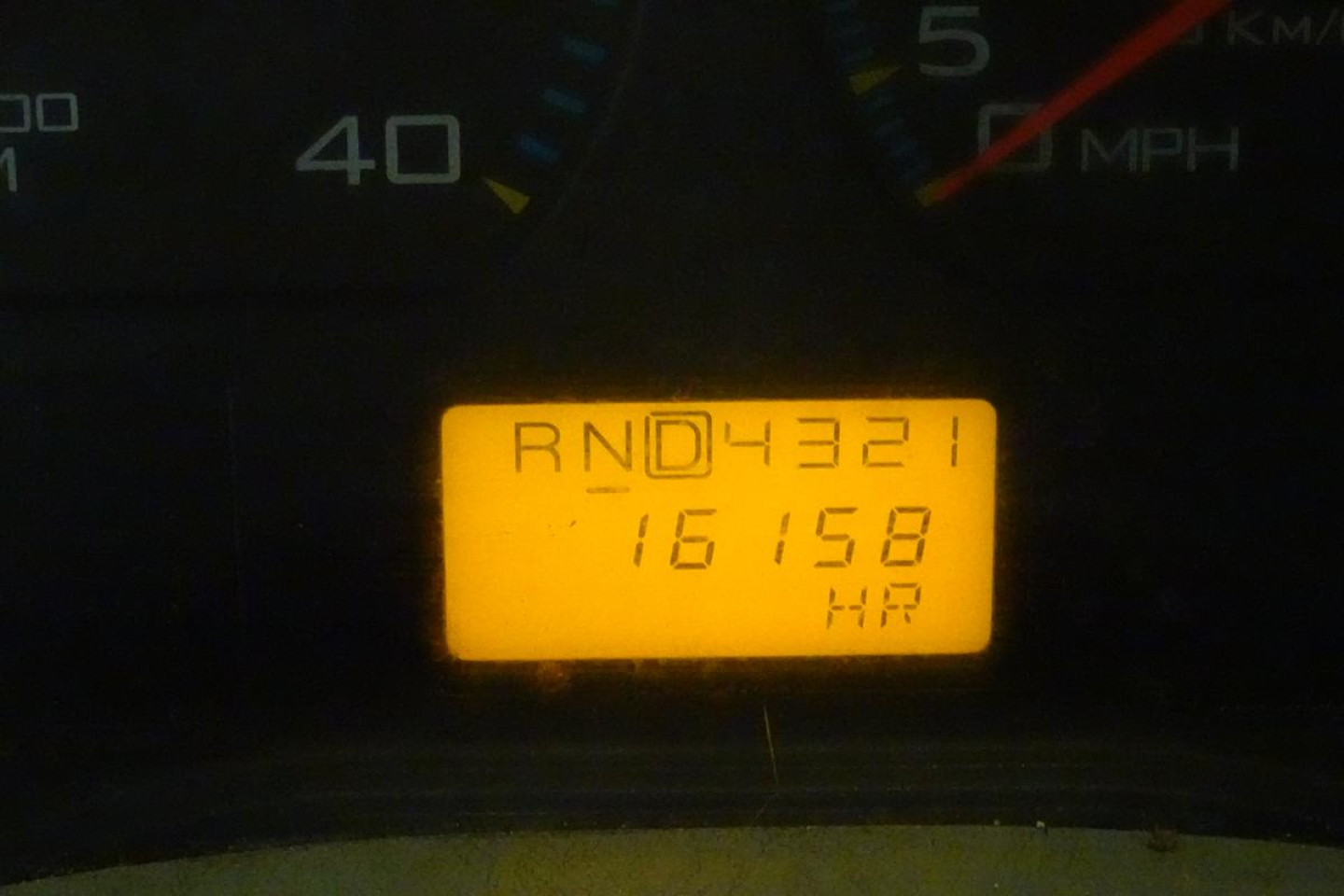 Dashboard odometer and gear indicator display showing RND4321 16158 HR on yellow/orange screen.