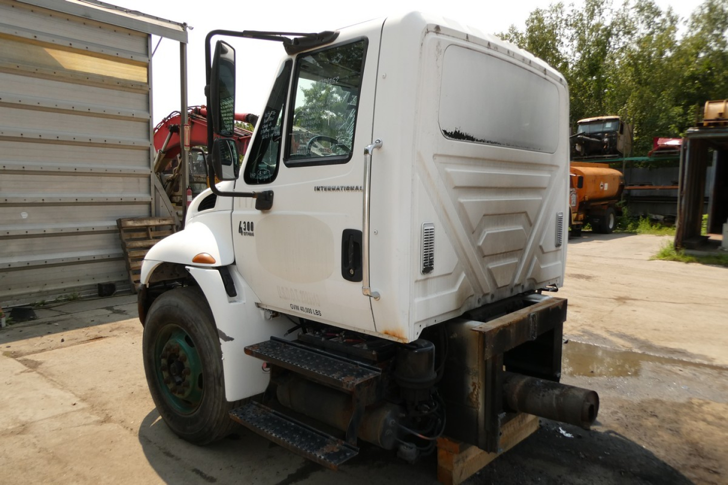 International 4300 cab with front step and dual exhaust, side view showing doors and windshield; visible text includes INTERNATIONAL on door and model numbers.