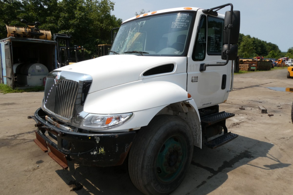 Front-left view of a white 2005 International 4300 truck with black bumper, large grille, and side steps.