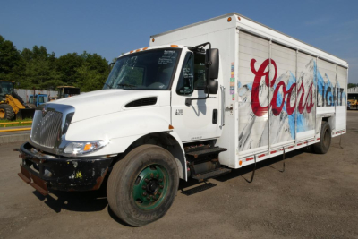 International 4300 box truck showing beverage body and Coors Light graphics with front bumper, cab, and raised hood.