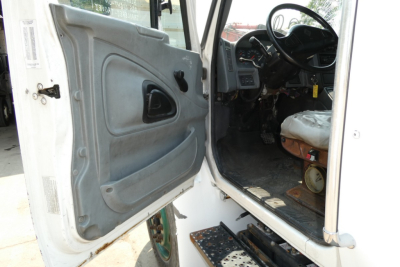 Truck door interior and cabin view of a 2005 International 4300 medium-duty truck showing open door and driver seat area.
