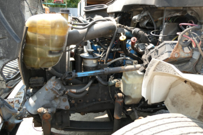 International 4300 engine bay view showing coolant reservoir and various hydraulic lines and components.
