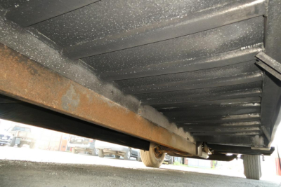 Underbody view of a 2005 International 4300 showing steel frame and cargo bed underside with some rust on the support beam.