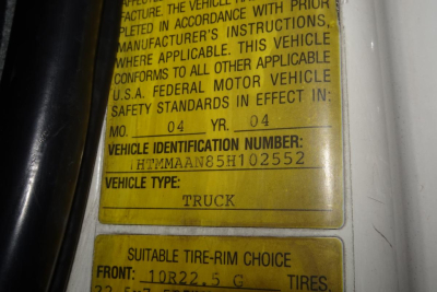 Vehicle identification label on a 2005 International 4300 showing Vehicle Identification Number 1HTMMAAN85H102552 and vehicle type TRUCK; yellow labels with MFD and year data.