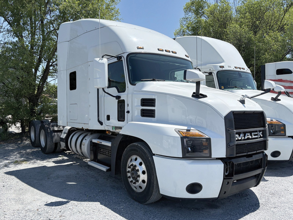 Mack Anthem tractor in white, side view showing front grille with Mack logo, sleeper cab, dual rear axles, daytime running lights, and fuel tanks.