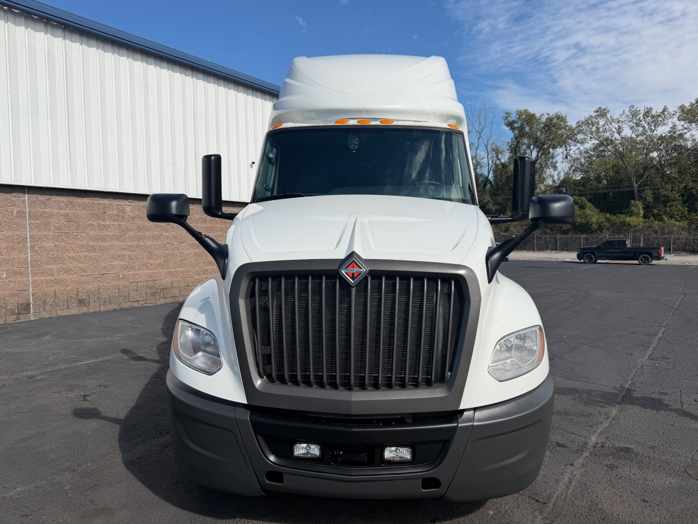 Front view of a white 2021 International LT625 sleeper truck with large black grille, rectangular headlights, and side mirrors. Roof sleeper cab visible.