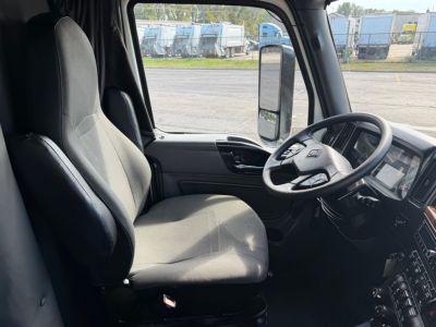 Interior cabin of a 2021 International LT625 truck showing driver seat and steering wheel, dash controls visible.