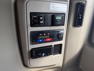 Interior dash panel of a 2021 International LT625 showing switches labeled ACCENT, EXIT, FLOOR LIGHT, and a multimedia head unit with controls.