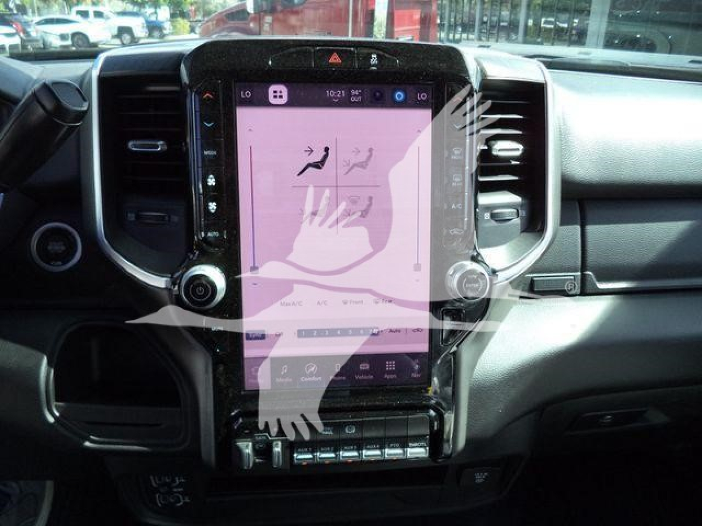 Ram 4500 dashboard center console showing large vertical touchscreen display with pink overlay and hands watermark.