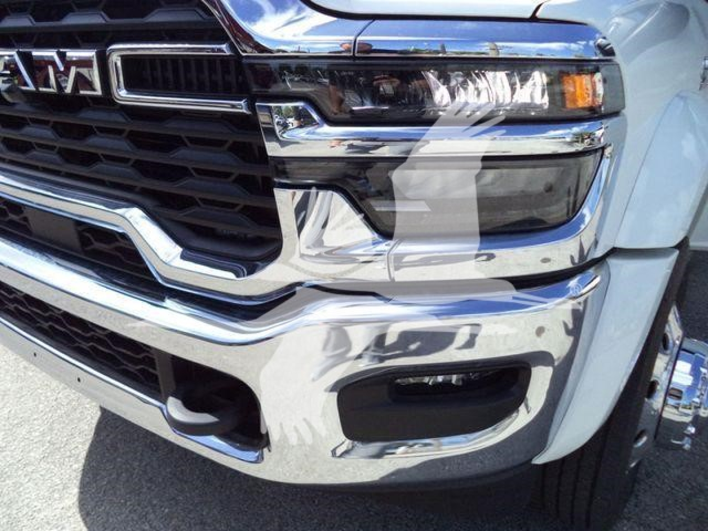 Front view of a 2026 Ram 4500 truck showing chrome grille, headlight, and bumper windows.