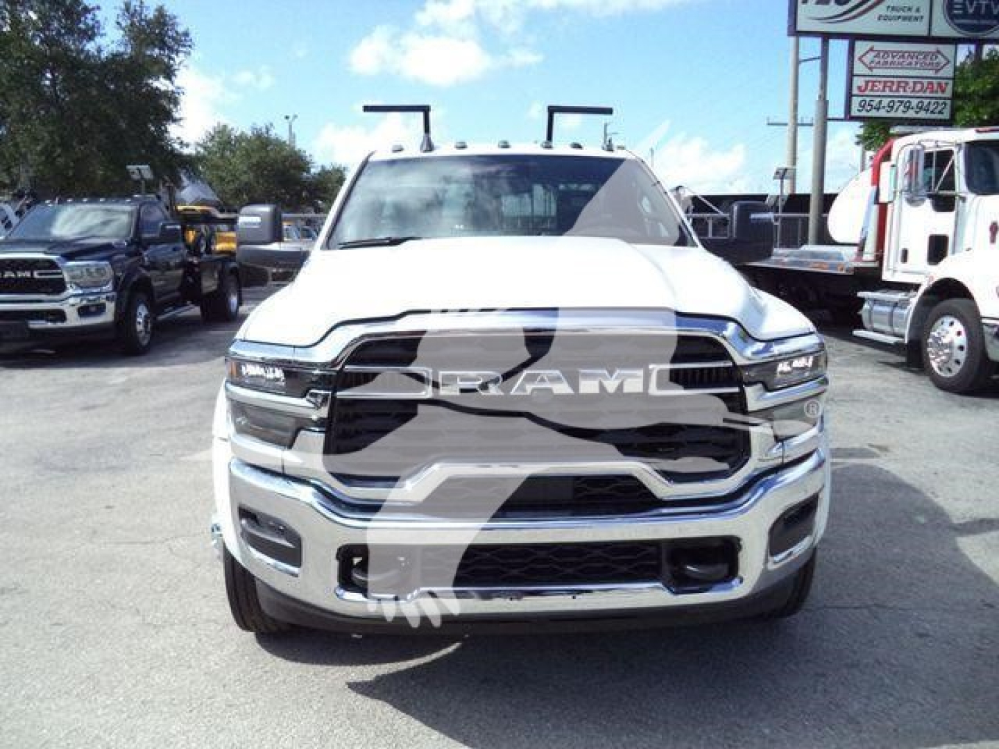 Ram 4500 front view showing large chrome grille and RAM lettering on hood, white pickup with winch equipment visible, dealership lot in background
