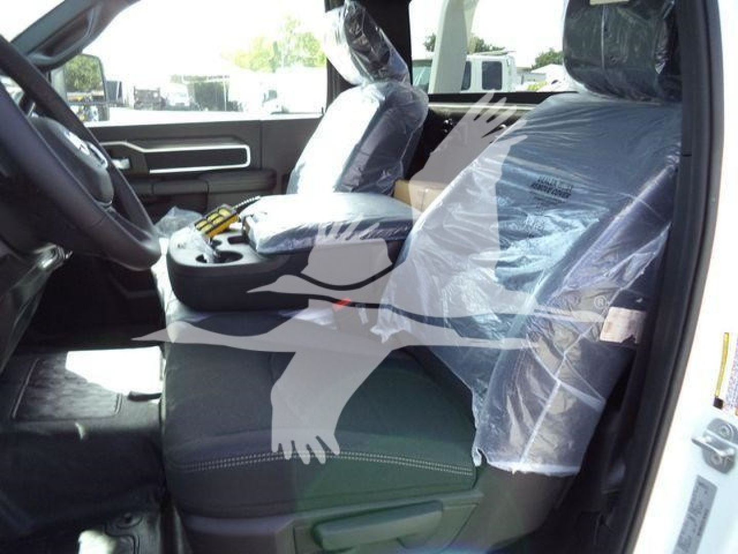 Inside cab of 2026 Ram 4500 pickup showing front seats with protective plastic covering and center console area.