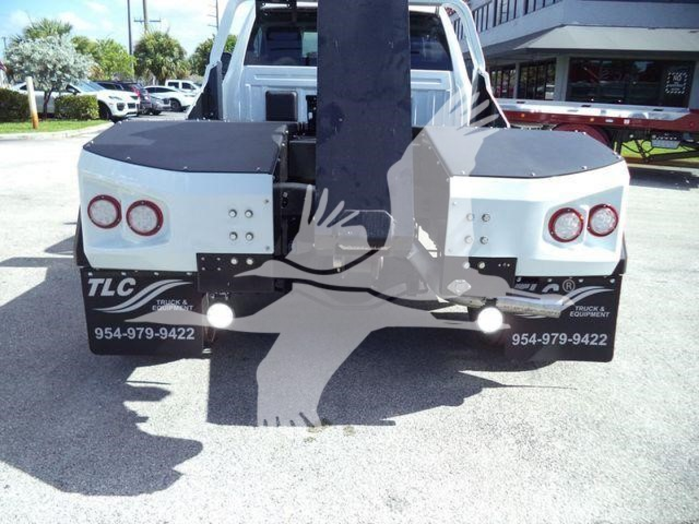 Ram 4500 winch truck rear with dual rear fenders, white body panels, and black tonneau covers; rear hitch and bumper area visible.