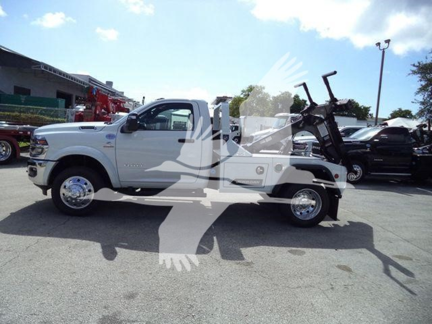 Ram 4500 pickup with a mounted winch assembly in a dealership lot, white body, extended cab, large dual rear tires, chrome wheels, VIN 3C7WRKAL0TG217748 visible on listing