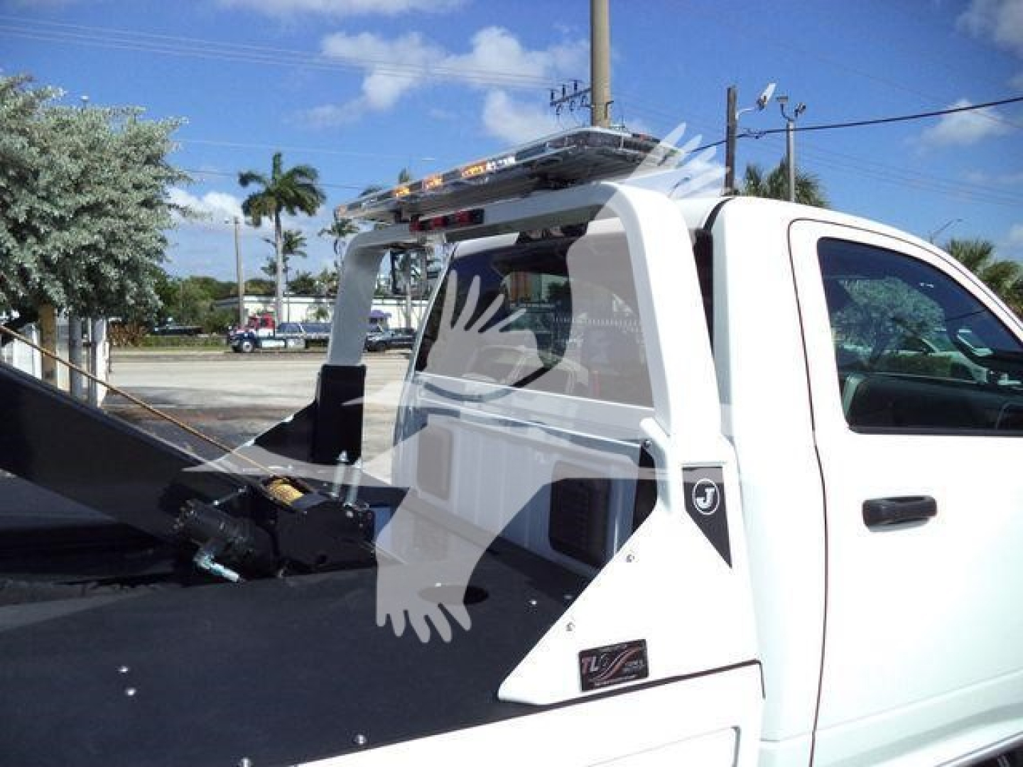 Ram 4500 pickup bed with winch setup and roll bar, white cab, VIN plate and stock number J17748 visible