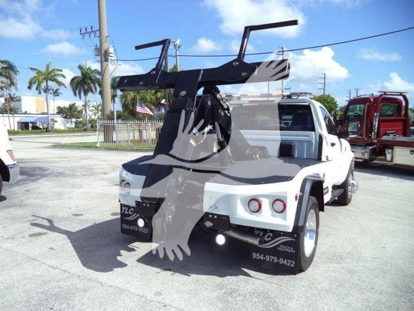 Ram 4500 tow Wrecker bed showing hitch winch arm and rear view with white cab and black winch assembly.