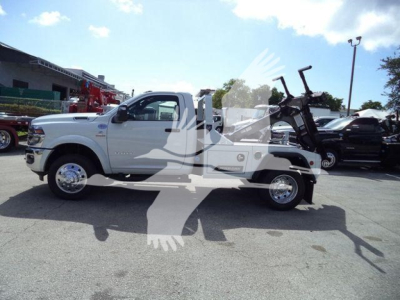 Ram 4500 pickup with a mounted winch assembly in a dealership lot, white body, extended cab, large dual rear tires, chrome wheels, VIN 3C7WRKAL0TG217748 visible on listing