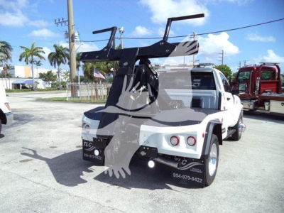 Ram 4500 tow Wrecker bed showing hitch winch arm and rear view with white cab and black winch assembly.
