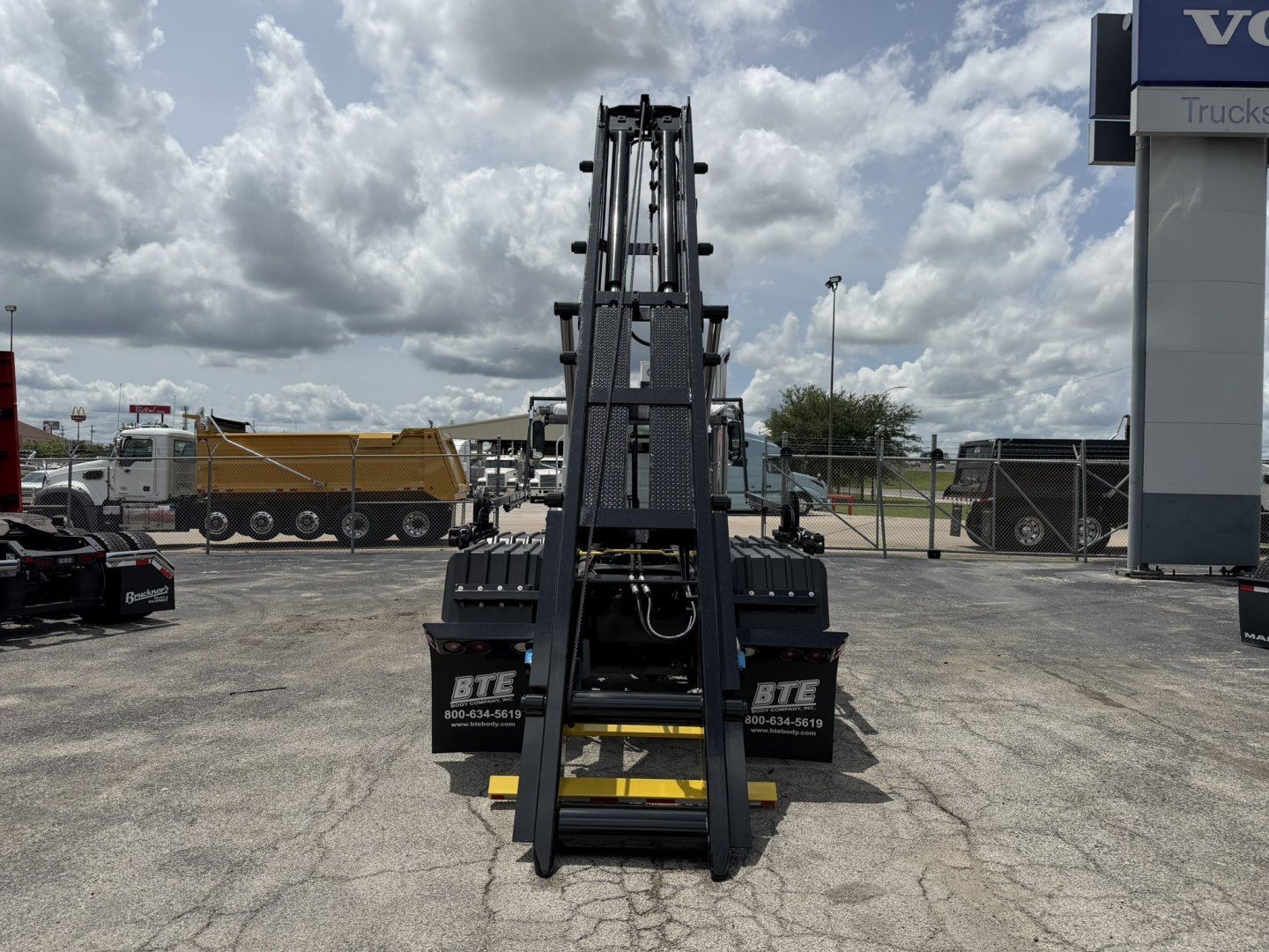 Front view of 2026 Mack GR64B roll-off truck chassis with fork attachments and hydraulic arms, VIN 1M2GR2GC9TM054664, stock 70393.