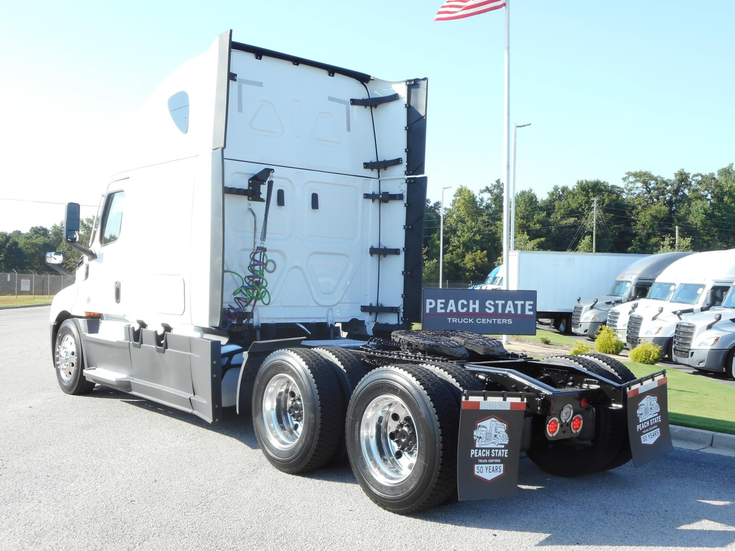 Freightliner Cascadia 126 semi-truck rear view with sleeper cab, dual rear axles, chrome wheels, and fifth-wheel area.