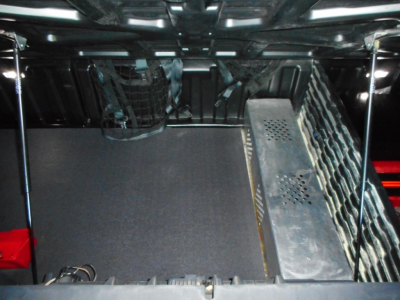 Truck interior cargo area of a 2024 Freightliner Cascadia 126 showing storage area and metal panels with perforations.