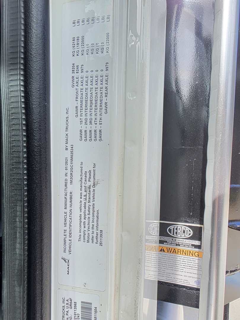 Mack GRANITE dump truck door sticker with VIN label and warning sticker; vertical sticker panel shows vehicle details and compliance text.