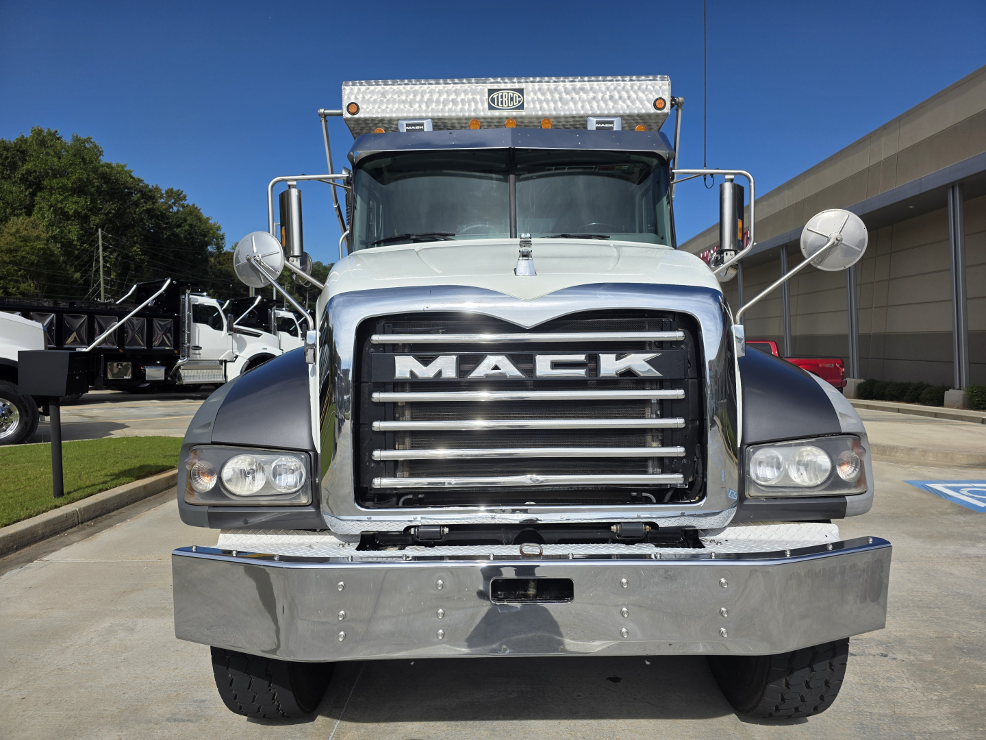 Front view of a white 2022 Mack Granite dump truck showing large chrome grille with MACK emblem, bumper, headlights, and hood. VIN not visible.