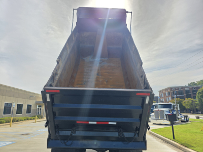 Dump truck bed in raised position showing Mack GRANITE chassis area and dump body interior text not visible.
