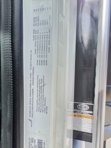 Mack GRANITE dump truck door sticker with VIN label and warning sticker; vertical sticker panel shows vehicle details and compliance text.