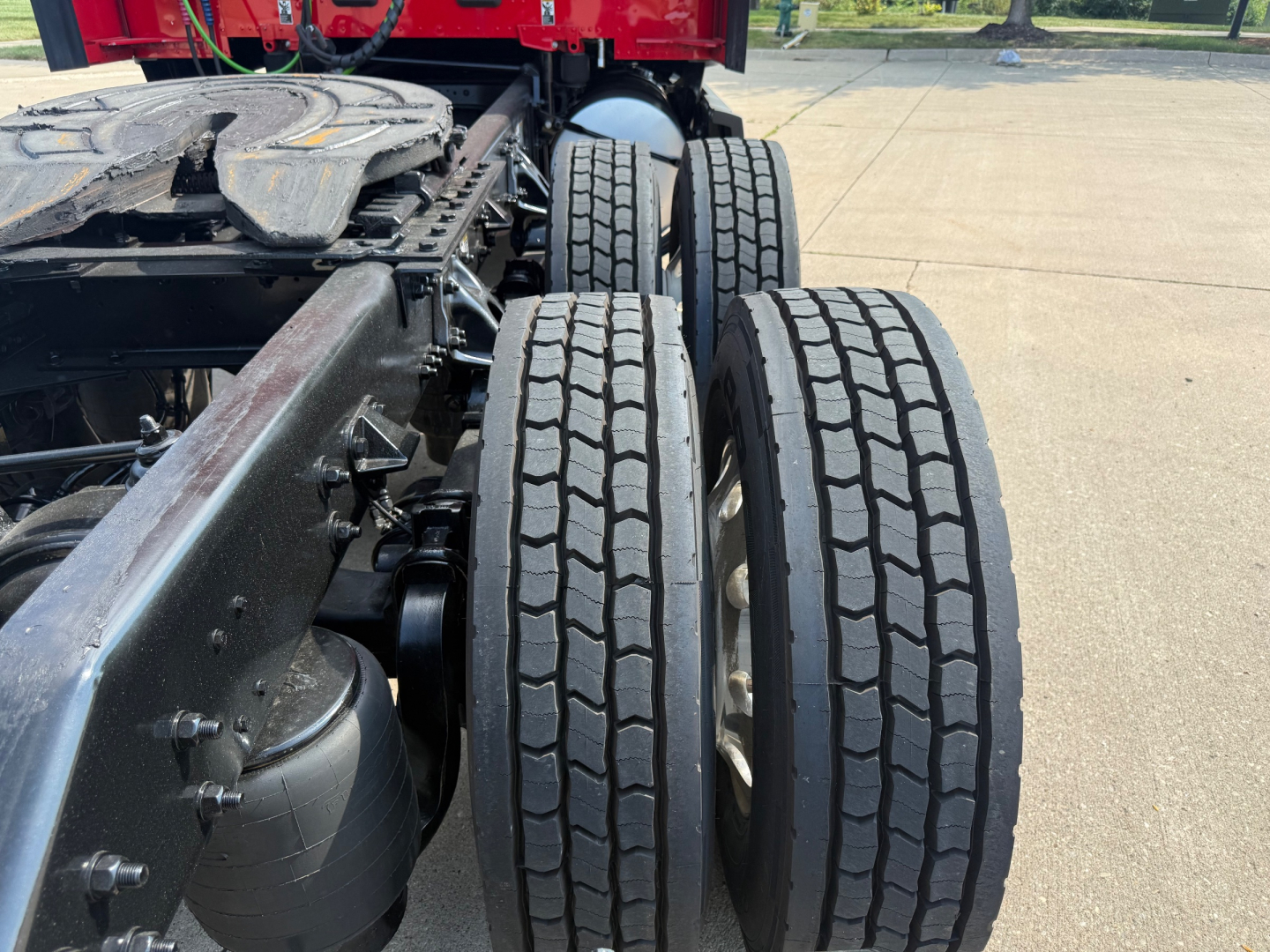 Kenworth T680 chassis with dual rear axles and tires visible, showing wheel rims and drivetrain near the frame rail.