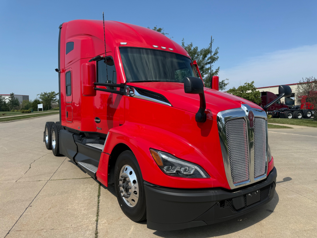 Kenworth T680 conventional sleeper truck in red, front three-quarter view showing chrome grille, headlights, and side mirror.