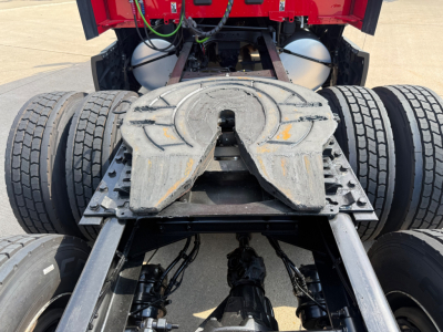 Kenworth T680 tractor rear showing fifth wheel mounting and dual rear axles with suspension components.