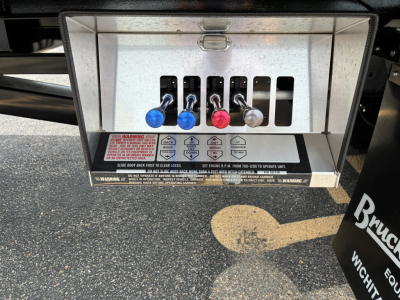 Mack GR64F rollback truck control panel with five colored levers and warning labels.