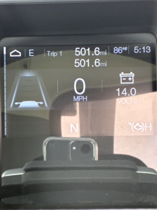 Vehicle driver display showing 0 mph, 501.6 mi trip, 14.0 volts, gear N, and battery icon on Mack GR64F truck dashboard.