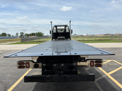 Mack GR64F rollback truck rear view showing flatbed surface and taillights.