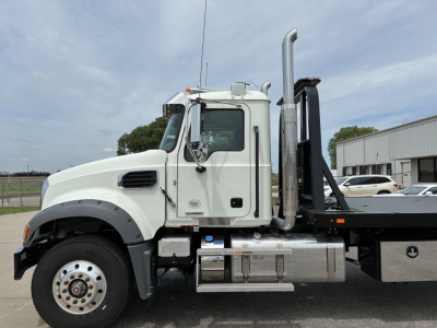 Mack GR64F rollback truck side view showing cab and exhaust stack with chrome fuel tanks and steps, VIN plate area not legible.