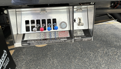 Truck service panel with multiple colored levers/gauges and label text. Includes five levers colored red, blue, and black, with control panel and warning/readout panels.